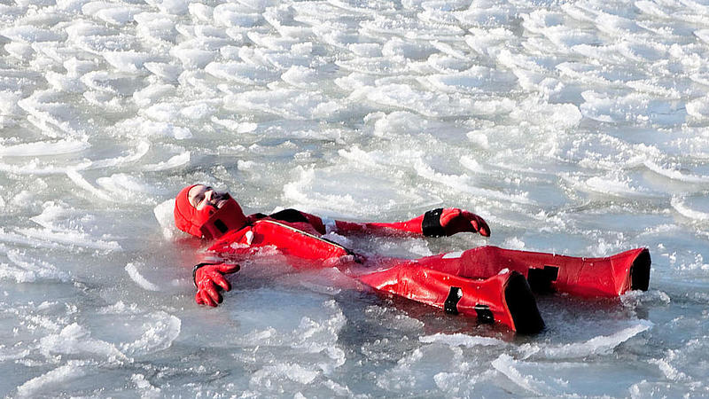 Person floating in ared suite in ice water.